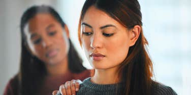 sad woman turned away from friend who will betray her