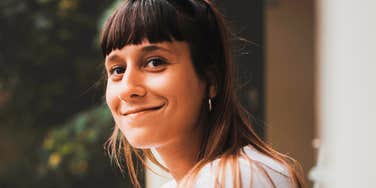 Woman smiling outdoors, illustrating attentive presence and strong communication habits during conversations