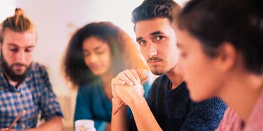 man feeling bored around large groups of his colleagues