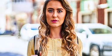 Young woman who had an unhappy childhood looking serious in a city