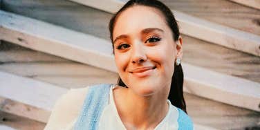 A woman smiling gently while looking at the camera.