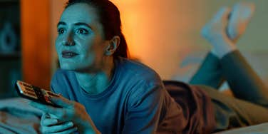 intelligent and happy woman staying up late watching television to have no responsibility