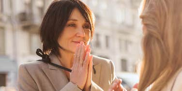 interested woman asking friend questions outside