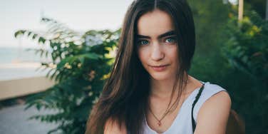 Empath woman who grew up in a chaotic home by a green plant