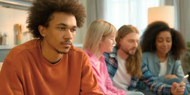 young man who hated group projects growing up sitting away from friends