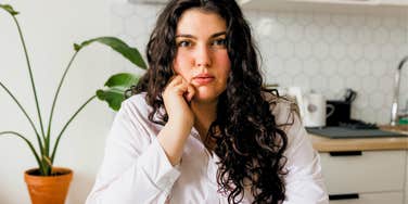 anxious woman sitting at the table shaking her leg