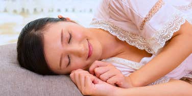 woman sleeping with T-rex arms in bed