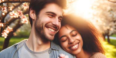 happy couple embracing under blooming trees at golden hour