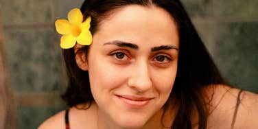 A woman smiling gently while looking at the camera.