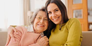 mother and adult daughter hugging having close relationship
