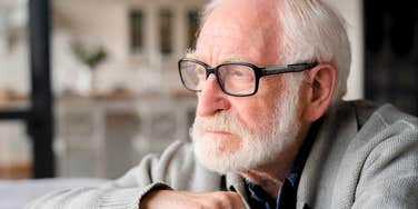 sad retired man sitting in silence at home alone