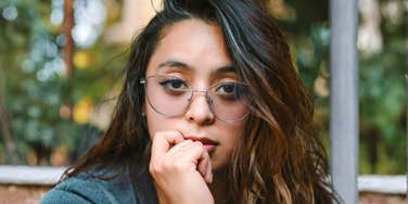 Woman staring blankly and nervously biting her lip, illustrating the discomfort of outgrowing an old identity