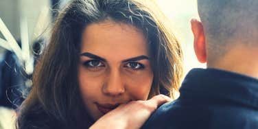 woman quietly working against someone looking vengeful