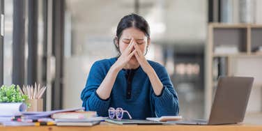 woman crying at work because she needs heartbreak leave after a breakup