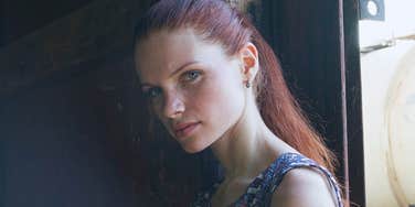 Woman who was parentified as a child stands by a window