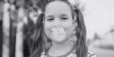 little girl who grew up in the 1960s blowing bubblegum