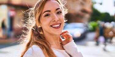 empathetic woman standing on the street spreading joy