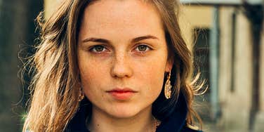 Woman who is struggling but doesn't want anyone to know looking serious