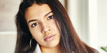 Woman who was singled out and felt unwanted as child looking serious