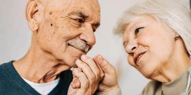 A lovely and vibrant couple in their sixties sharing a moment of genuine connection, illustrating the 'perfect life' found in emotional intimacy rather than material success.