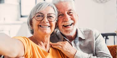 A happy older couple hugging and smiling, illustrating that choosing separate beds or 'sleep divorce' can actually strengthen a relationship and improve comfort in later years.