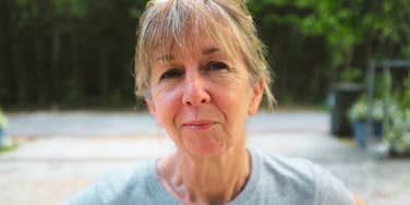 A happy woman with blonde hair and bangs looking satisfied and empowered, representing the 'surprising changes' that lead to finding meaningful work in your sixties.