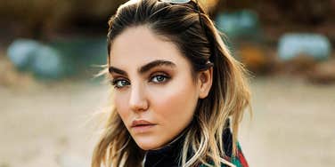 A woman looking back with a serious, sad expression, reflecting the emotional toll and confusion of experiencing gaslighting in a relationship.