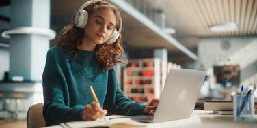 college student working in library with laptop