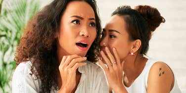 Friend telling a shocking secret to another woman, capturing the high-stakes emotional triggers and early marriage challenges discussed by relationship experts.