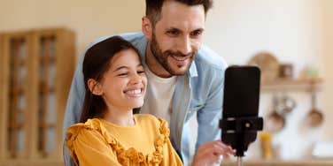dad and daughter filming video on phone 