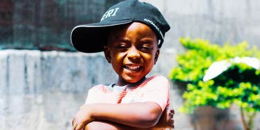 Nineties kid wearing a hat outdoors with a calm, confident expression, illustrating the self-assured traits experts say many 1980s and 1990s kids developed