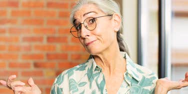 A senior woman with a thoughtful, puzzled expression, representing the moment of realization when parents begin to consider how their habits affect their adult children.