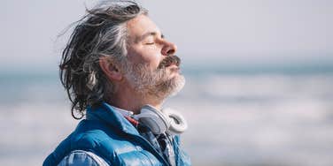 Humble man who appreciates what he has standing at the beach 