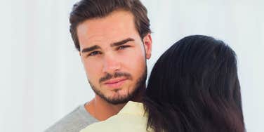 unhappy man hugging wife but not caring about her at all