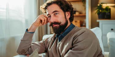 pensive man sitting at home thinking about his finances