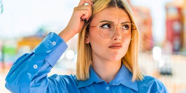 woman scratching her head confused