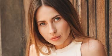 A woman with a serious, guarded expression, representing the long-term psychological impact of growing up in an emotionally distant household.