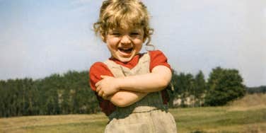 Vintage photo of a little girl laughing outdoors, illustrating the civility and social ease many kids raised in the 1960s and 1970s developed