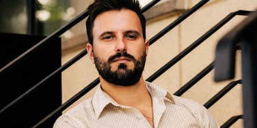 Man looking directly at the camera with a subtle expression, illustrating expert signs that he likes you but not enough for a serious relationship