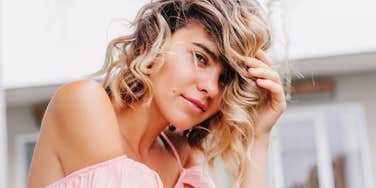 Blonde woman looking directly at the camera outdoors, illustrating behaviors that suggest someone hasn’t fully moved on from their ex