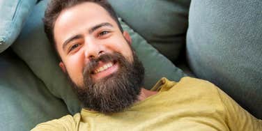 Man who plans to stay sharp into old age smiling on a couch