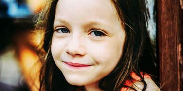 A young girl with a bright, engaged expression, representing the 'executive function' skills and critical thinking habits taught by intentional parents.