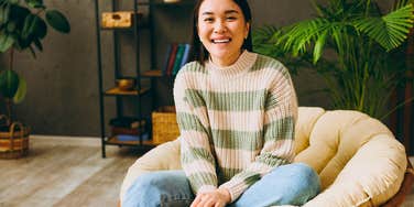 smiling happy woman sitting with one foot tucked under her