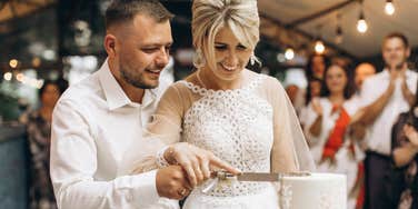 bride and groom cutting cake at wedding
