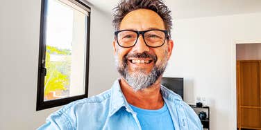 A stylish man in his fifties taking a selfie, capturing the excitement of a new life chapter and the realization that life gets easier with a clear perspective.