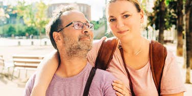 A joyful middle-aged couple enjoying a moment in nature, representing the emotional resilience and optimistic mindset of adults who maintain healthy lifestyle routines.