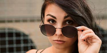 woman putting sunglasses down realizing things she thought were modern have been around a long time