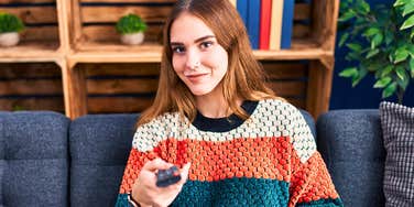 woman on the couch rewatching her comfort shows
