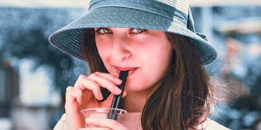 woman who hates paper straws using plastic straw in drink