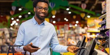 man using self-checkout at the grocery store